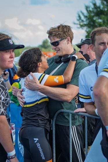 Supporters omhelzen een deelneemster over het hek heen