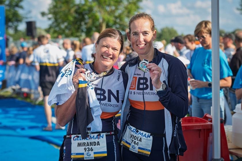 Twee deelneemsters laten samen hun finishersmedaille zien