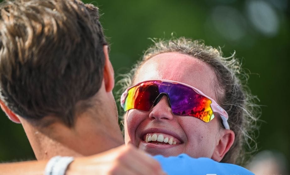 Finisher lacht in de armen van een supporter vlak na de streep