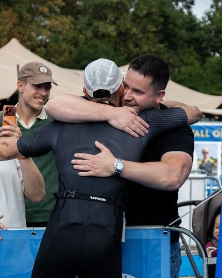 Twee mannen omhelzen elkaar na de finish