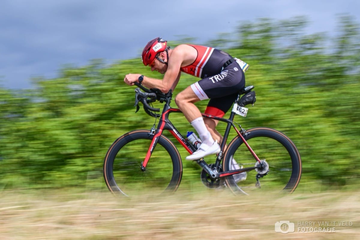 Deelnemer op de tijdritfiets over een Betuwse dijk